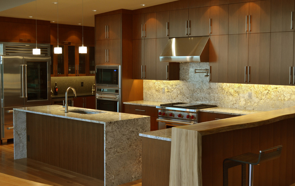 Example of a large trendy u-shaped medium tone wood floor and brown floor open concept kitchen design in Seattle with an undermount sink, flat-panel cabinets, medium tone wood cabinets, granite countertops, gray backsplash, stone slab backsplash, stainless steel appliances and an island