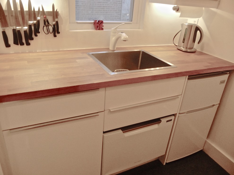 Esempio di una piccola cucina lineare contemporanea chiusa con lavello da incasso, ante lisce, ante bianche, top in legno, elettrodomestici bianchi e parquet scuro
