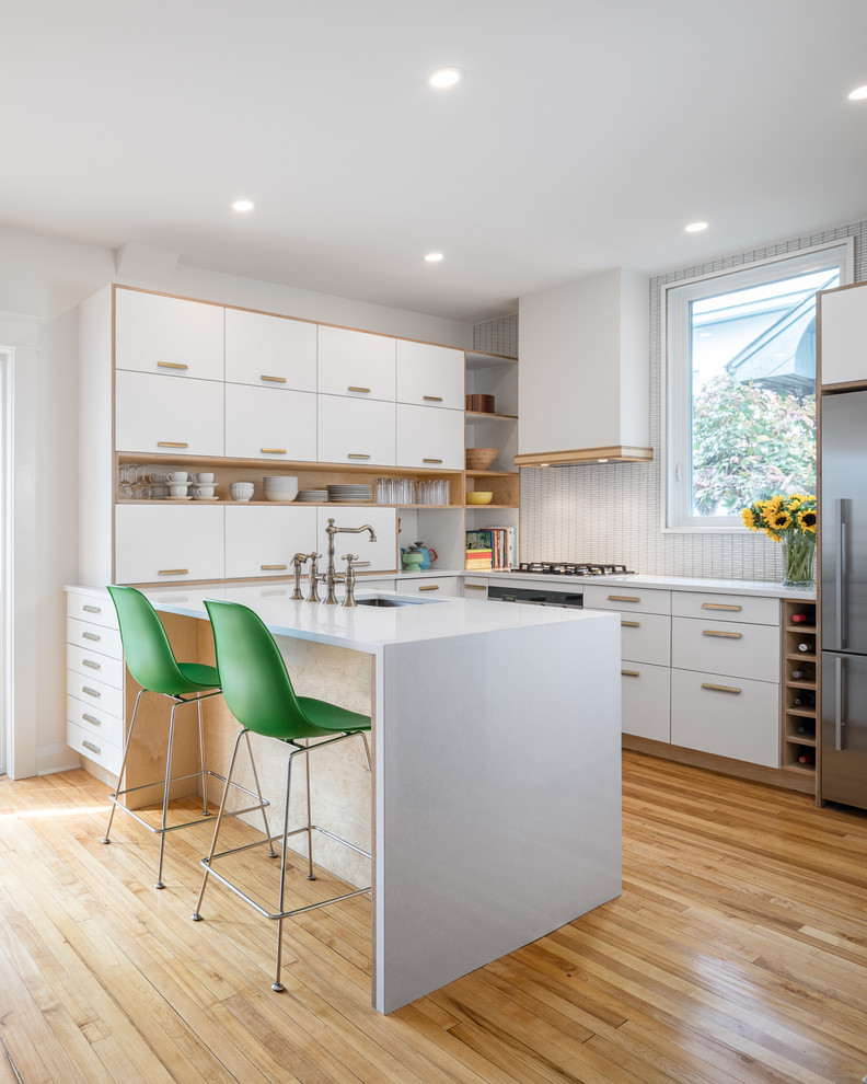 Eat-in kitchen - small contemporary u-shaped light wood floor eat-in kitchen idea in Ottawa with an undermount sink, flat-panel cabinets, white cabinets, quartzite countertops, white backsplash, ceramic backsplash and stainless steel appliances