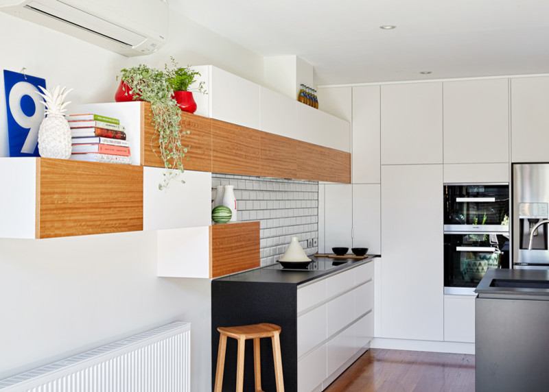Mittelgroße Moderne Küche mit Küchenrückwand in Weiß, Rückwand aus Metrofliesen, Küchengeräten aus Edelstahl und Kücheninsel in Melbourne