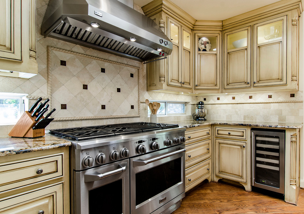 Elegant u-shaped eat-in kitchen photo in Dallas with an undermount sink, beige cabinets, granite countertops, beige backsplash, stone tile backsplash and stainless steel appliances