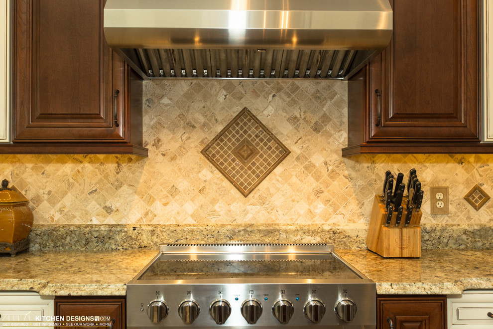 Example of a mid-sized classic u-shaped travertine floor eat-in kitchen design in Orlando with an undermount sink, raised-panel cabinets, dark wood cabinets, granite countertops, beige backsplash, stone tile backsplash and an island