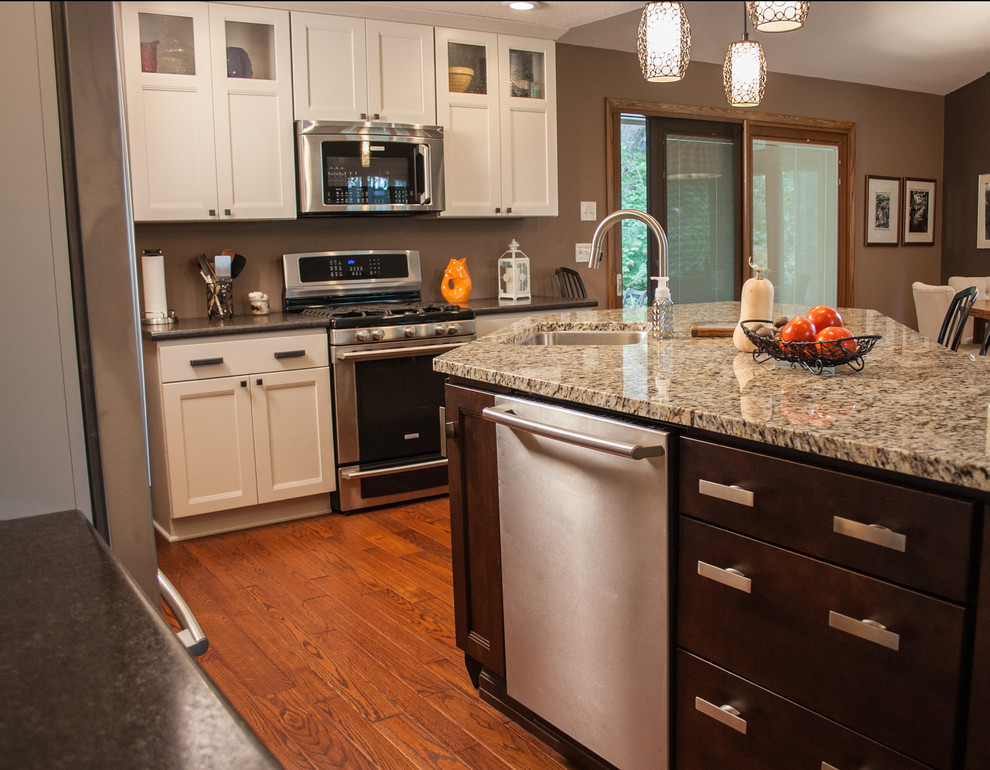 Exempel på ett mellanstort modernt kök, med en undermonterad diskho, luckor med infälld panel, vita skåp, granitbänkskiva, rostfria vitvaror, mellanmörkt trägolv och en köksö