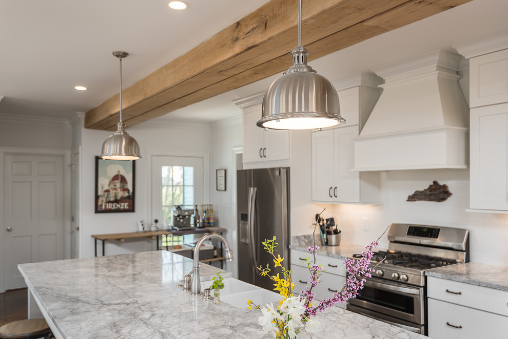 Inspiration for a mid-sized transitional galley medium tone wood floor and brown floor open concept kitchen remodel in Other with a farmhouse sink, shaker cabinets, white cabinets, granite countertops, white backsplash, subway tile backsplash, stainless steel appliances and an island