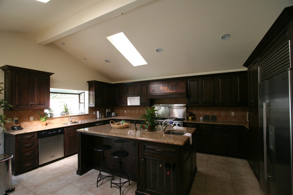Mittelgroße Klassische Küche in U-Form mit dunklen Holzschränken, Granit-Arbeitsplatte, Küchenrückwand in Beige, Rückwand aus Zementfliesen, Küchengeräten aus Edelstahl, Marmorboden und Kücheninsel in Los Angeles