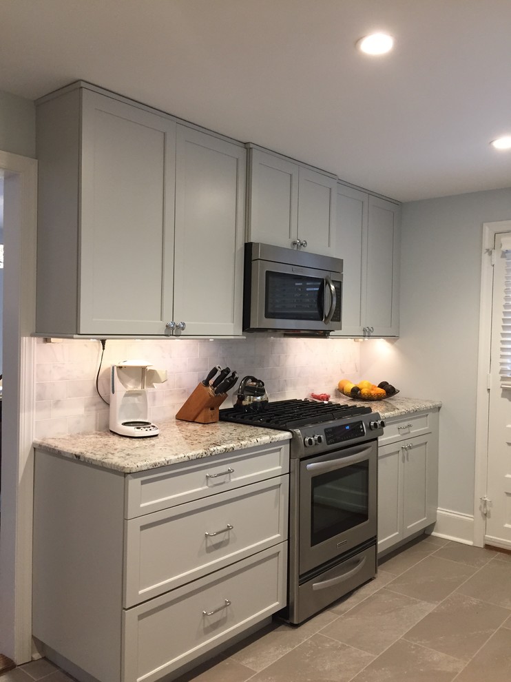 Example of a small transitional galley enclosed kitchen design in Philadelphia with an undermount sink, shaker cabinets, gray cabinets, granite countertops, gray backsplash, stone tile backsplash, stainless steel appliances and no island