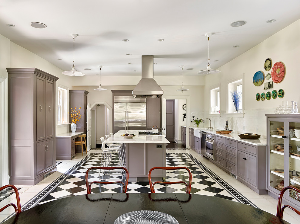 Inspiration for a large transitional l-shaped cement tile floor and multicolored floor eat-in kitchen remodel in Philadelphia with a farmhouse sink, glass-front cabinets, gray cabinets, quartzite countertops, white backsplash, ceramic backsplash, stainless steel appliances and an island