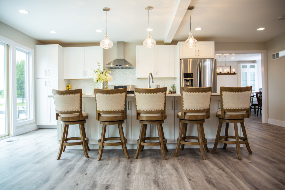 Small transitional single-wall vinyl floor and brown floor eat-in kitchen photo in Chicago with white cabinets, an island, multicolored backsplash, stainless steel appliances, white countertops, a farmhouse sink, shaker cabinets, quartz countertops and mosaic tile backsplash