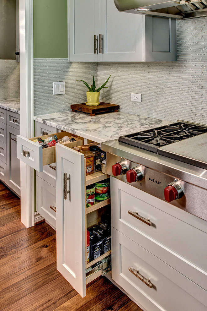 Große Klassische Küche in U-Form mit Vorratsschrank, Waschbecken, grauen Schränken, Küchenrückwand in Weiß, Küchengeräten aus Edelstahl, dunklem Holzboden und Kücheninsel in Seattle