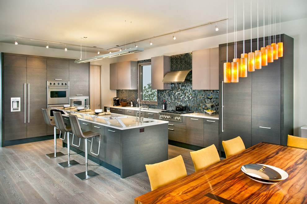Eat-in kitchen - huge contemporary galley light wood floor and gray floor eat-in kitchen idea in Atlanta with paneled appliances, flat-panel cabinets, gray cabinets, quartz countertops, an island, an undermount sink, metallic backsplash and glass tile backsplash