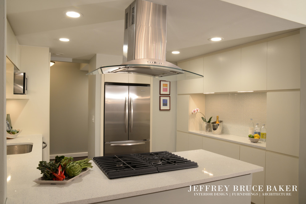 Bild på ett litet funkis kök, med en undermonterad diskho, släta luckor, vita skåp, bänkskiva i koppar, vitt stänkskydd, stänkskydd i glaskakel, rostfria vitvaror och mellanmörkt trägolv