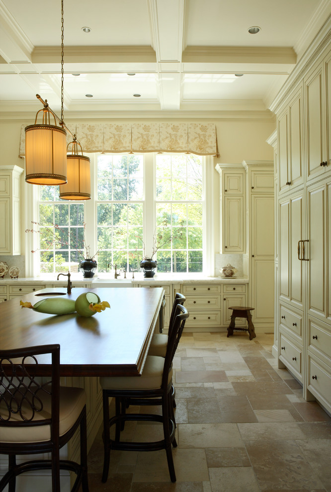 Example of a classic kitchen design in Atlanta with a farmhouse sink, raised-panel cabinets, white cabinets, white backsplash and marble countertops