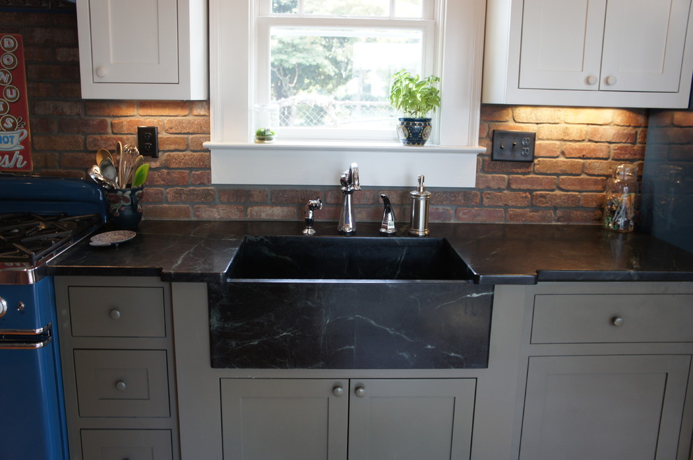 Exempel på ett mellanstort lantligt kök, med en rustik diskho, skåp i shakerstil, vita skåp, färgglada vitvaror, ljust trägolv, en köksö, bänkskiva i täljsten, stänkskydd i tegel och brunt golv