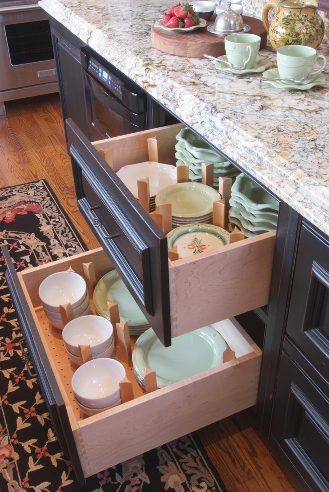 Inspiration for a mid-sized timeless u-shaped medium tone wood floor open concept kitchen remodel in Philadelphia with an undermount sink, beaded inset cabinets, black cabinets, granite countertops, black appliances and an island