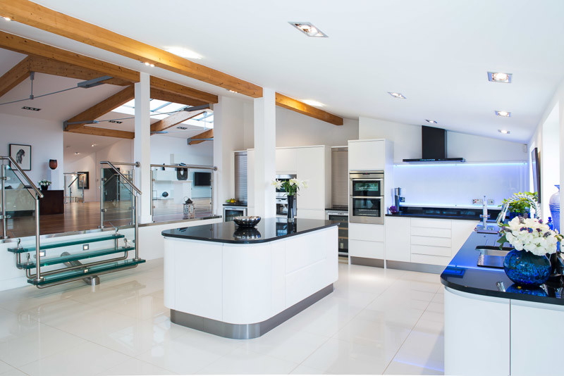 На фото: кухня-гостиная среднего размера в современном стиле с плоскими фасадами, белыми фасадами, мраморной столешницей, островом и белым полом с