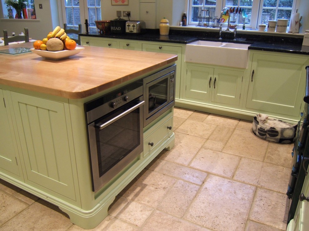 Idee per una cucina classica di medie dimensioni con lavello stile country, ante in stile shaker, ante verdi, top in granito e pavimento in pietra calcarea