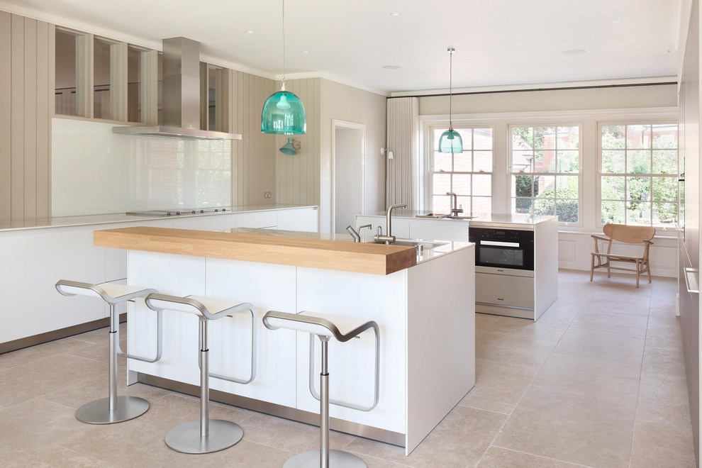 Danish beige floor enclosed kitchen photo in London with flat-panel cabinets, white cabinets, white backsplash, glass sheet backsplash, two islands and white countertops