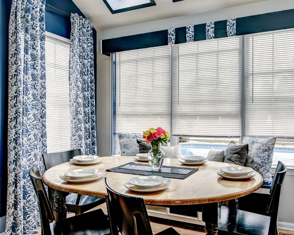 Foto di una piccola sala da pranzo aperta verso la cucina tradizionale con pareti blu e pavimento in laminato