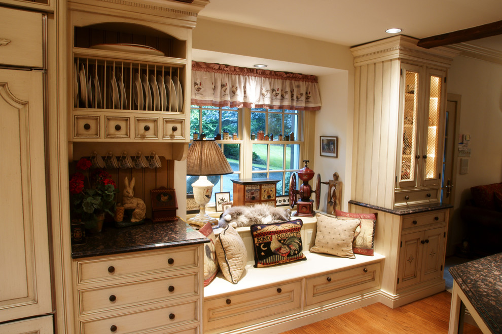 Example of a mid-sized farmhouse u-shaped medium tone wood floor eat-in kitchen design in Philadelphia with an undermount sink, beaded inset cabinets, beige cabinets, granite countertops, multicolored backsplash, paneled appliances, a peninsula and terra-cotta backsplash
