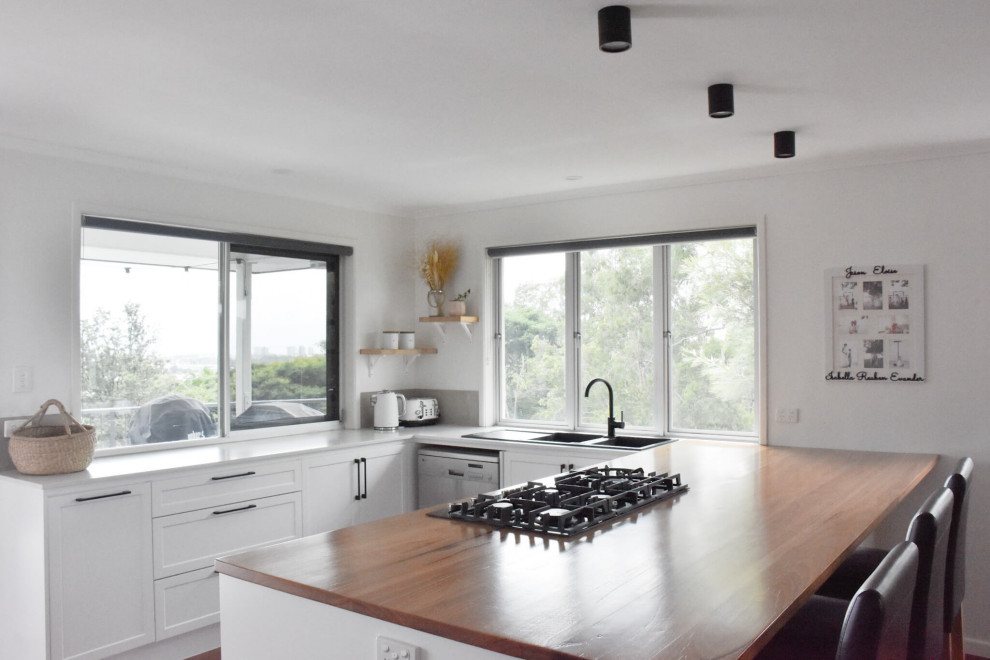 Foto di una cucina design di medie dimensioni con ante in stile shaker, ante bianche, top in legno e pavimento in legno massello medio