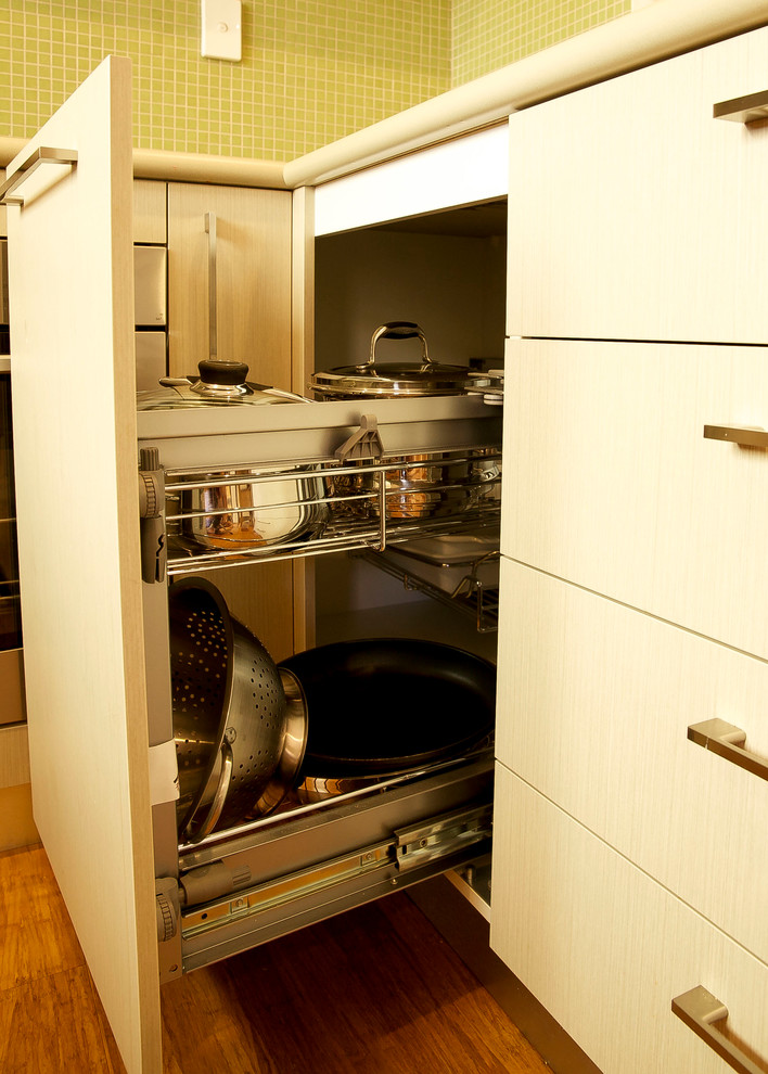 Foto de cocina moderna pequeña con fregadero de doble seno, encimera de laminado, salpicadero gris, salpicadero de azulejos de vidrio, electrodomésticos de acero inoxidable y suelo de madera en tonos medios