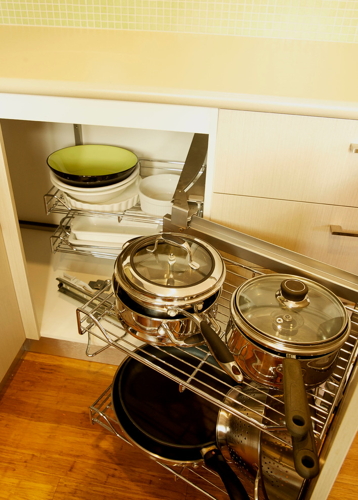 Foto di una piccola cucina minimalista con lavello a doppia vasca, top in laminato, paraspruzzi verde, paraspruzzi con piastrelle di vetro, elettrodomestici in acciaio inossidabile e pavimento in legno massello medio