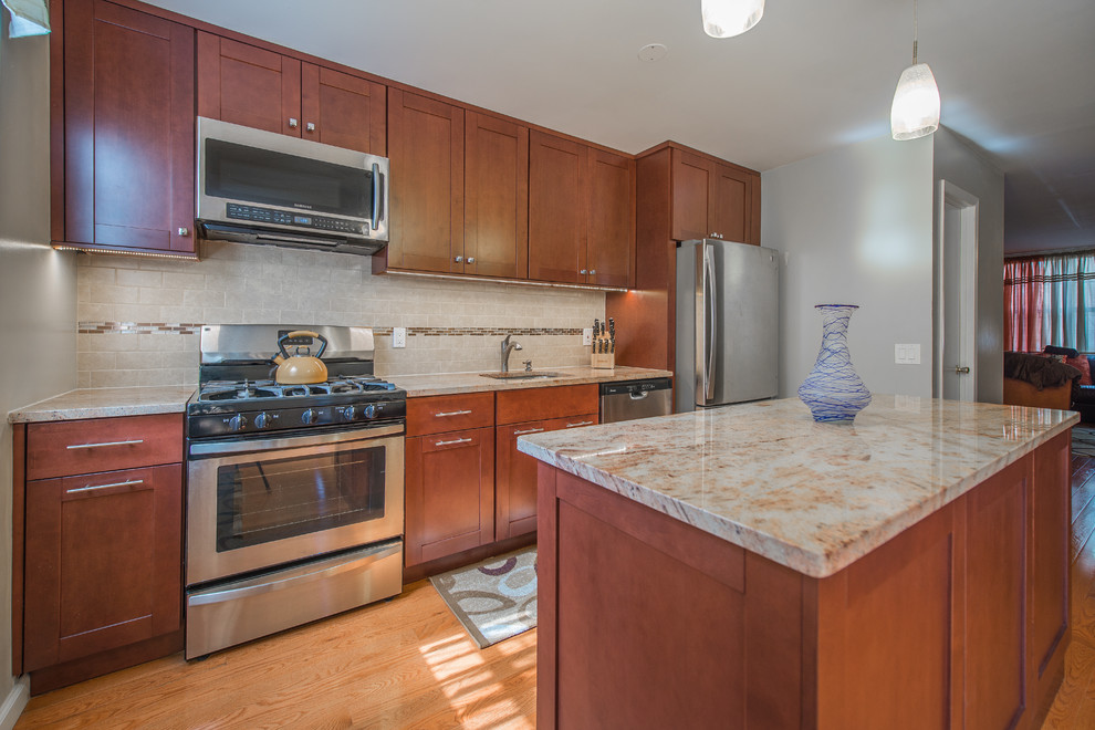 Exempel på ett mellanstort klassiskt linjärt kök och matrum, med en undermonterad diskho, skåp i shakerstil, skåp i mellenmörkt trä, granitbänkskiva, brunt stänkskydd, rostfria vitvaror, mellanmörkt trägolv, en köksö och stänkskydd i stenkakel