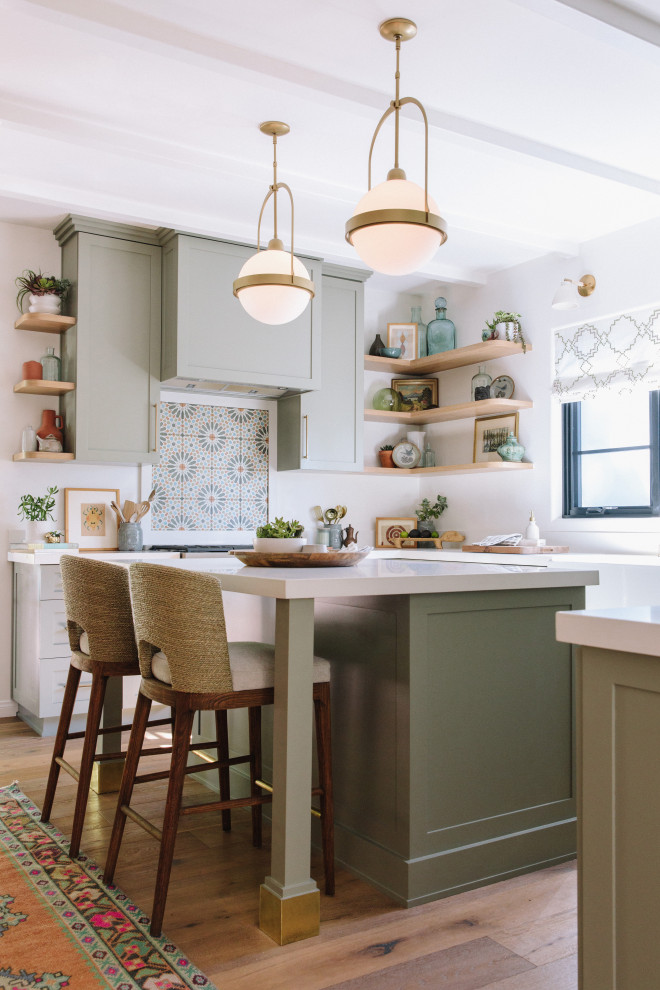 Idéer för vintage vitt u-kök, med en rustik diskho, skåp i shakerstil, gröna skåp, bänkskiva i kvarts, vitt stänkskydd, mellanmörkt trägolv, en köksö och brunt golv
