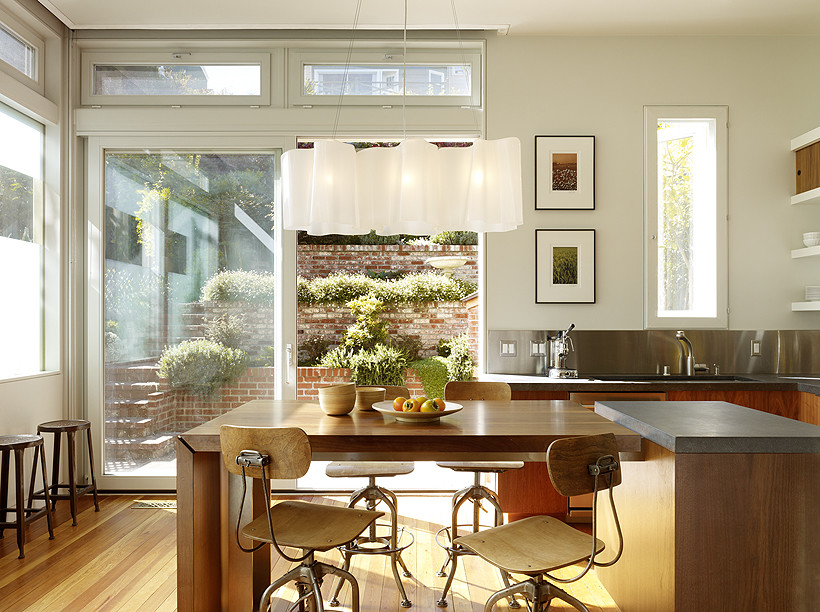 Minimalist light wood floor eat-in kitchen photo in San Francisco with flat-panel cabinets, light wood cabinets, soapstone countertops, metallic backsplash and stainless steel appliances