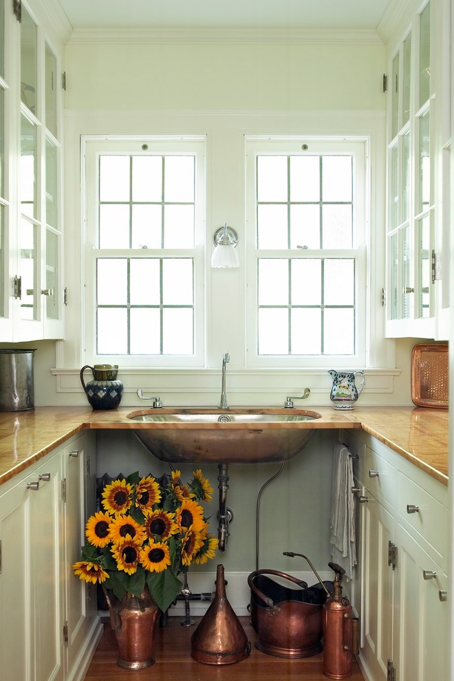 Inspiration för ett litet vintage kök, med en undermonterad diskho, luckor med infälld panel, vita skåp, träbänkskiva, vitt stänkskydd och ljust trägolv