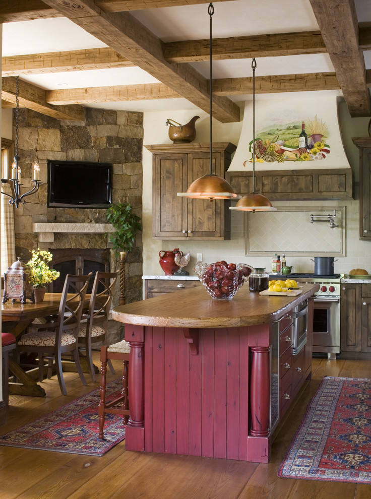 Inredning av ett rustikt kök, med rostfria vitvaror och träbänkskiva