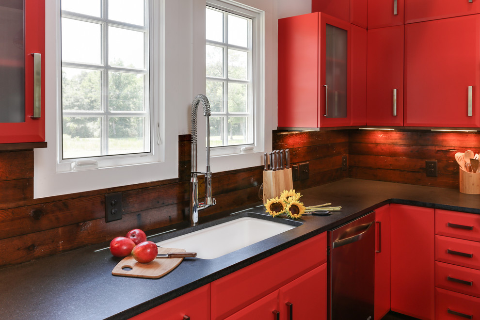 ローリーにある高級な小さなカントリー風のおしゃれなキッチン (シングルシンク、フラットパネル扉のキャビネット、赤いキャビネット、御影石カウンター、茶色いキッチンパネル、シルバーの調理設備、濃色無垢フローリング、木材のキッチンパネル) の写真