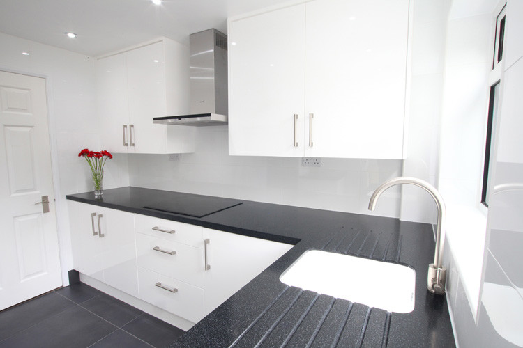 Foto di una piccola cucina a L minimalista chiusa con lavello sottopiano, ante bianche, top in superficie solida e nessuna isola