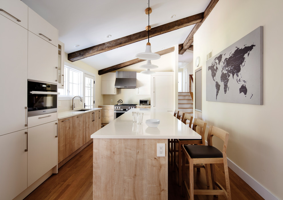 Esempio di una cucina contemporanea con lavello sottopiano, ante lisce, ante in legno chiaro, elettrodomestici in acciaio inossidabile e pavimento in legno massello medio
