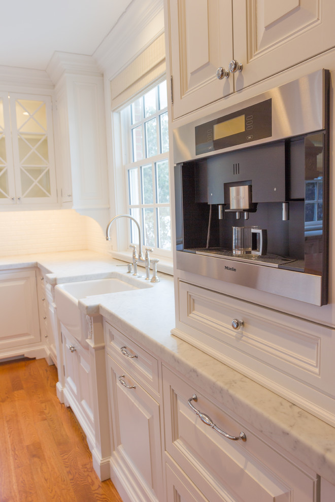Example of a huge classic u-shaped eat-in kitchen design in New York with a farmhouse sink, white cabinets, limestone countertops, white backsplash, subway tile backsplash and stainless steel appliances