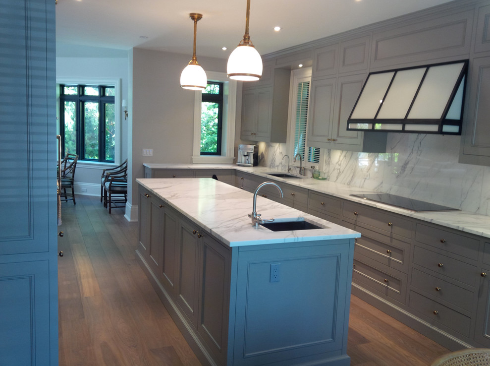 Inspiration for a large contemporary l-shaped kitchen/diner in Toronto with a submerged sink, recessed-panel cabinets, grey cabinets, marble worktops, white splashback, stone slab splashback, stainless steel appliances, medium hardwood flooring and an island.