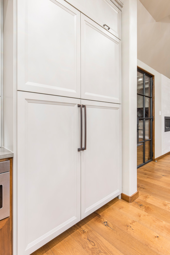 Immagine di una cucina con ante in stile shaker, ante grigie, elettrodomestici da incasso, pavimento in legno massello medio e pavimento marrone