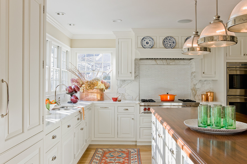 Klassische Küche mit Arbeitsplatte aus Holz, profilierten Schrankfronten, weißen Schränken, Rückwand aus Stein und Küchengeräten aus Edelstahl in Boston