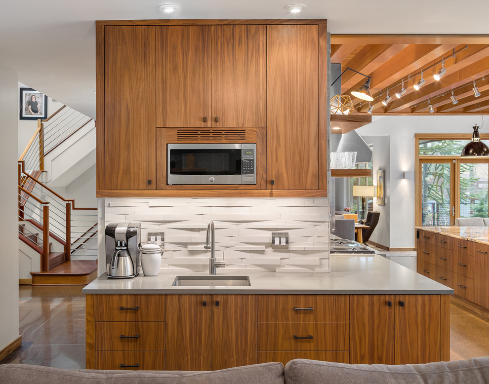 Example of a large trendy galley concrete floor eat-in kitchen design in Portland with an undermount sink, flat-panel cabinets, medium tone wood cabinets, granite countertops, beige backsplash, stone tile backsplash, stainless steel appliances and an island