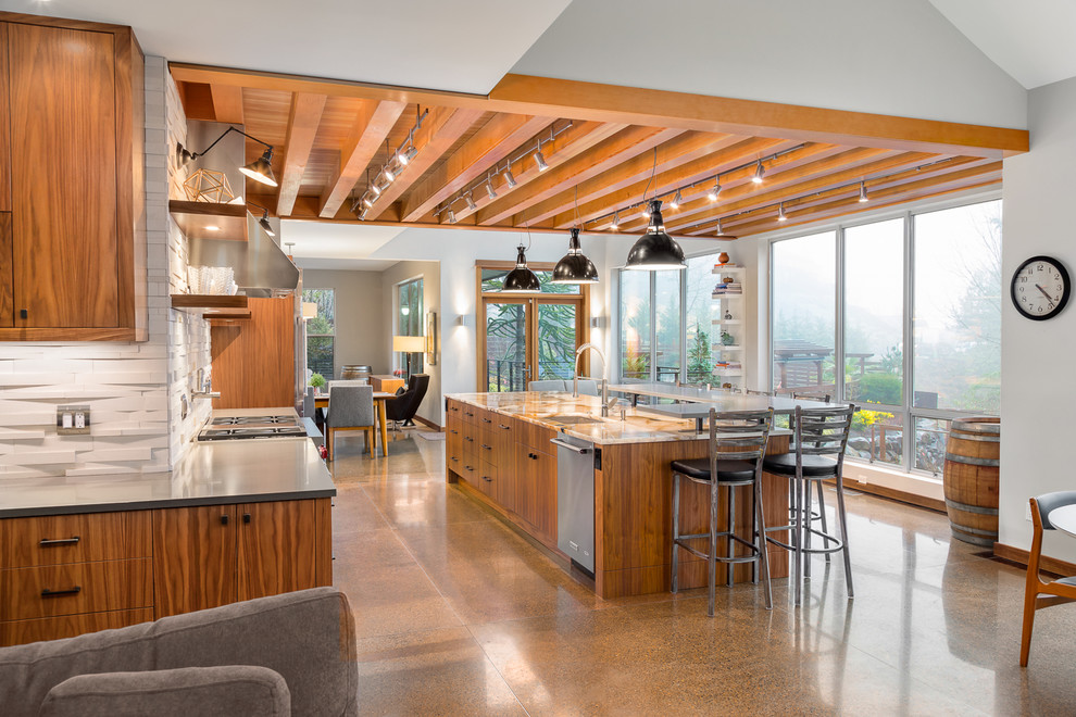Eat-in kitchen - large contemporary galley concrete floor eat-in kitchen idea in Portland with an undermount sink, flat-panel cabinets, medium tone wood cabinets, granite countertops, beige backsplash, stone tile backsplash, stainless steel appliances and an island