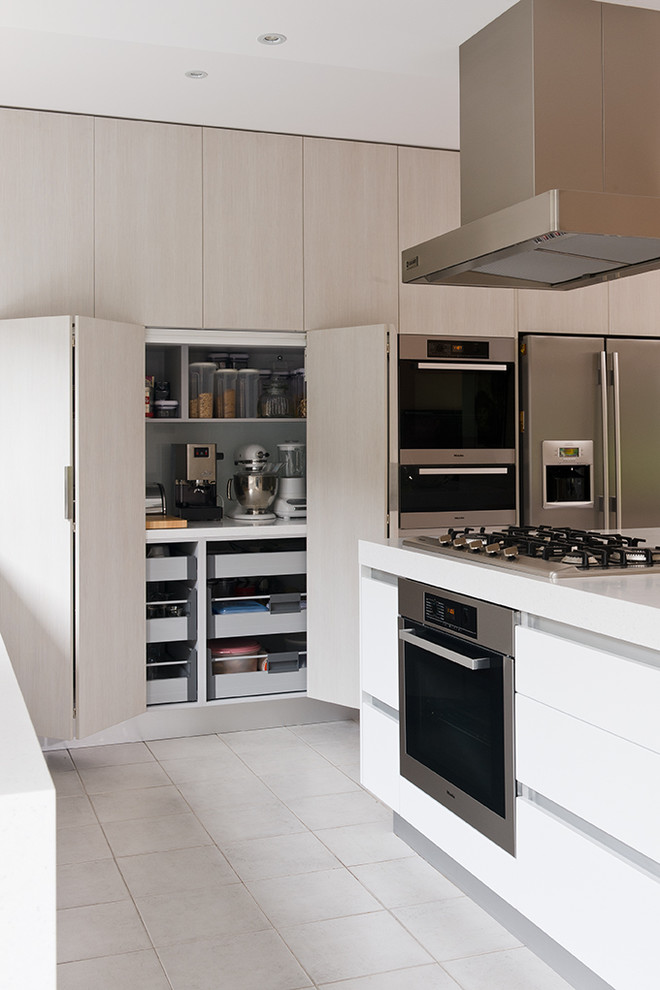 Bild på ett mellanstort funkis kök, med en undermonterad diskho, släta luckor, vita skåp, bänkskiva i koppar, rostfria vitvaror, klinkergolv i keramik och en köksö