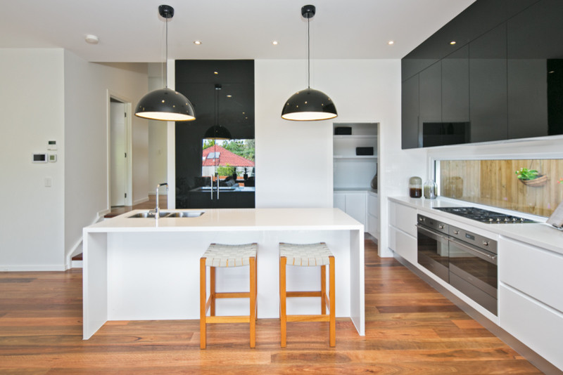 Foto di una cucina minimal con lavello sottopiano, elettrodomestici bianchi e parquet chiaro