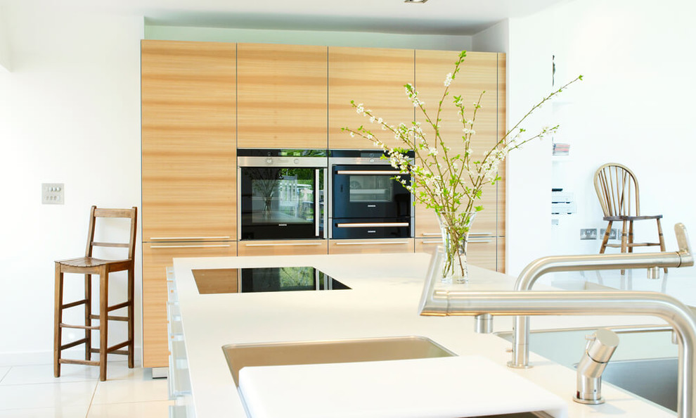 Immagine di una cucina contemporanea di medie dimensioni con lavello integrato, ante lisce, ante bianche, top in laminato, elettrodomestici neri e pavimento in gres porcellanato