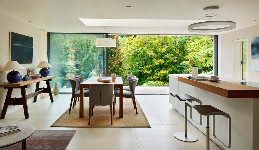 Immagine di una cucina minimal di medie dimensioni con lavello integrato, ante lisce, ante bianche, top in laminato, elettrodomestici neri, pavimento in gres porcellanato e pavimento beige