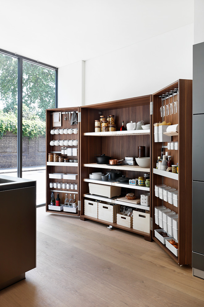 Cette image montre une cuisine ouverte linéaire design de taille moyenne avec un placard à porte plane, un plan de travail en surface solide et îlot.