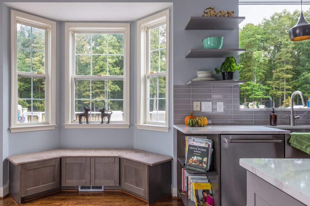 Large trendy u-shaped medium tone wood floor eat-in kitchen photo in DC Metro with an undermount sink, shaker cabinets, gray cabinets, quartz countertops, gray backsplash, porcelain backsplash, stainless steel appliances and an island