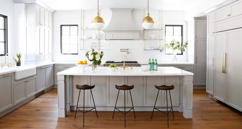 Mid-sized transitional medium tone wood floor eat-in kitchen photo in Los Angeles with white backsplash, subway tile backsplash, stainless steel appliances and an island