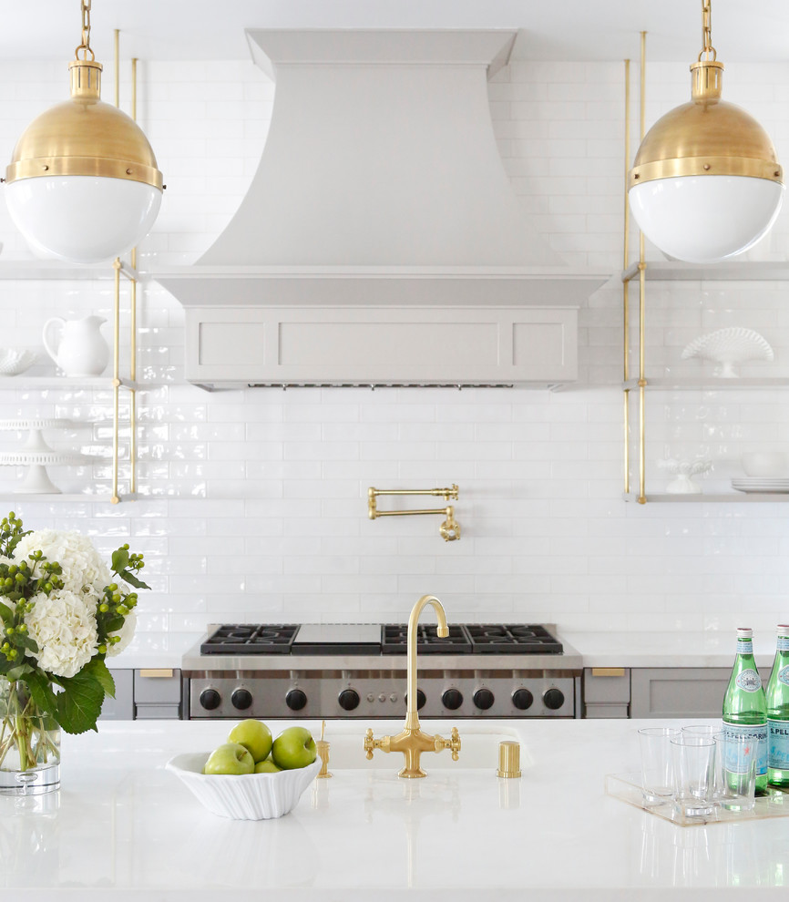 Foto de cocina comedor tradicional renovada de tamaño medio con salpicadero blanco, salpicadero de azulejos tipo metro, electrodomésticos de acero inoxidable y una isla