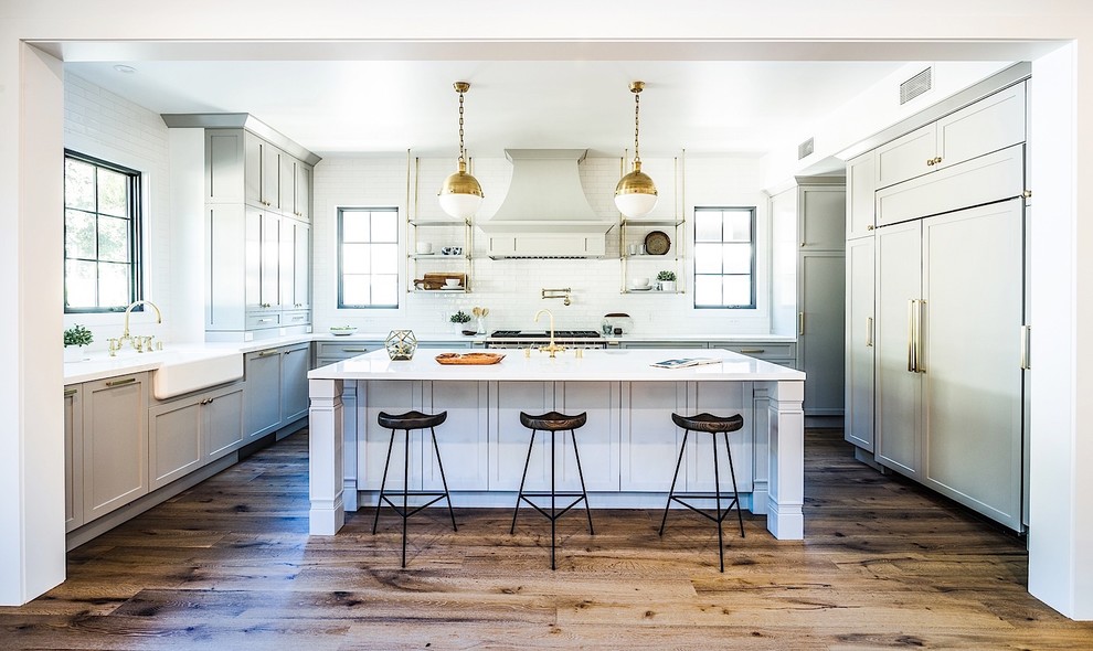 Inspiration for a mid-sized transitional medium tone wood floor eat-in kitchen remodel in Los Angeles with white backsplash, subway tile backsplash, stainless steel appliances and an island