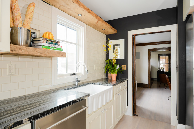 This is an example of a small bohemian galley enclosed kitchen in Minneapolis with a belfast sink, recessed-panel cabinets, white cabinets, marble worktops, yellow splashback, metro tiled splashback, stainless steel appliances and light hardwood flooring.